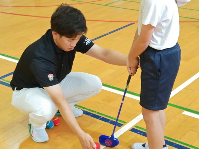大阪府トップアスリートふれあい事業1学期

5/30（金）、大阪市立清江小学校の皆さんにプロゴルファーの後藤大翔プロがスナッグゴルフを教えてくださいました。

初めてのスナッグゴルフに当初は戸惑いもあった生徒さんたちでしたが、グリップの握り方やスタンスなど、後藤プロの丁寧なアドバイスでメキメキ上達していました🏌️‍♂️

プロと生徒さんのガチンコ対決では、ハンデ2打を背負った後藤プロがまさかの"ホールインワン"で計3打！対する生徒さんは1打目を約2mにしっかり寄せ、プレッシャーのかかる中、見事なパッティングで2打であがり、勝利しました🏅

皆様有難うございました。
お疲れさまでした！

#ジュニアゴルフクラブチーム連盟
#ジュニアゴルフ
#ジュニアゴルファー
#JGCF #スナッグゴルフ　
#エンジョイゴルフ #スクランブルゴルフ #ゴルフ部 #ゴルフ #生涯スポーツ #しばケア #目土 #目土をしよう！ #挨拶 #加盟チーム募集中